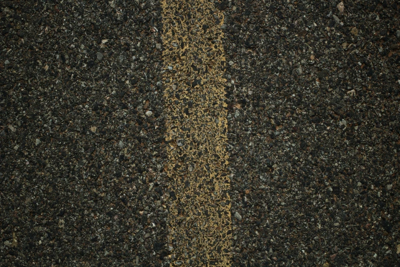 a black asphalt street with yellow striped asphalt