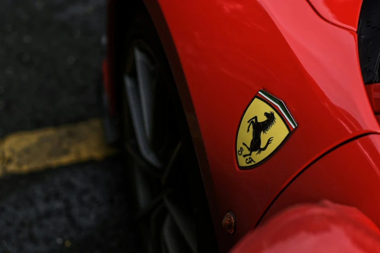 the ferrari badge is visible on the rear end of a red car