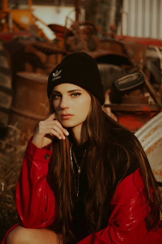 a woman in a red jacket posing near a wreck