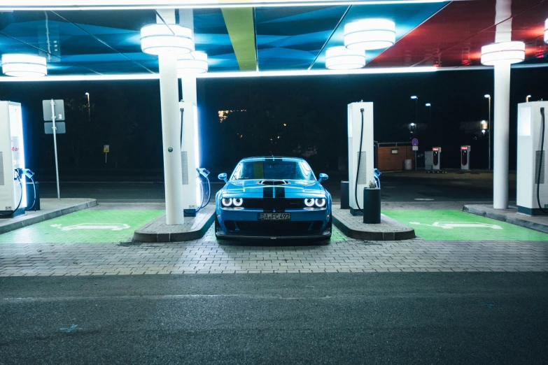 a blue race car sits at the gas pump