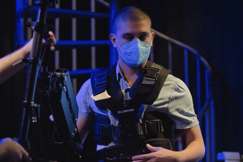 man wearing a face mask with suspenders playing guitar