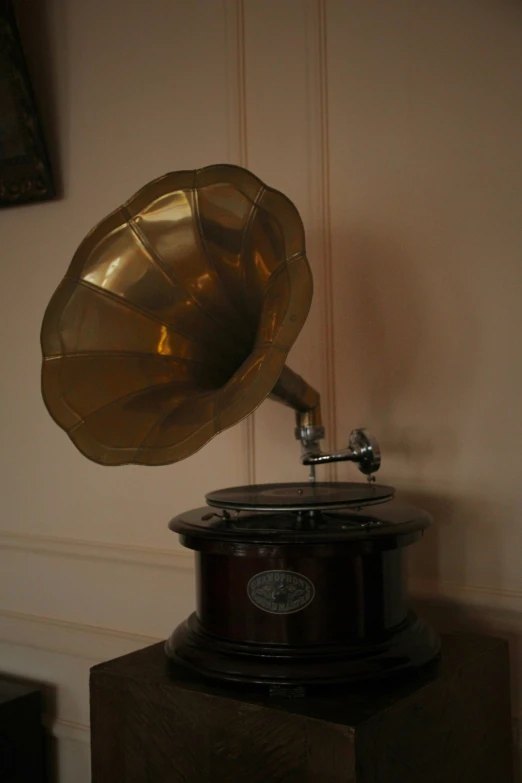 an antique record player on display against a beige wall