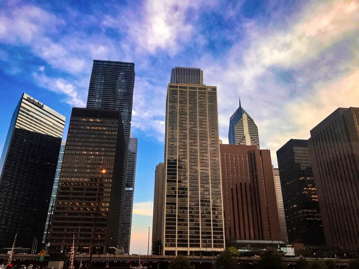 the tall buildings have lights on at dusk