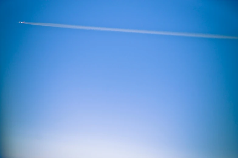 the airplane flies high in the blue sky
