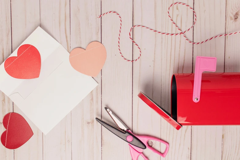 a pair of scissors next to a cut out hearts on top of a wooden surface