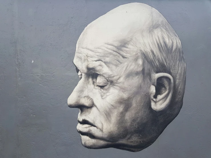 an old man's head is displayed behind a glass wall