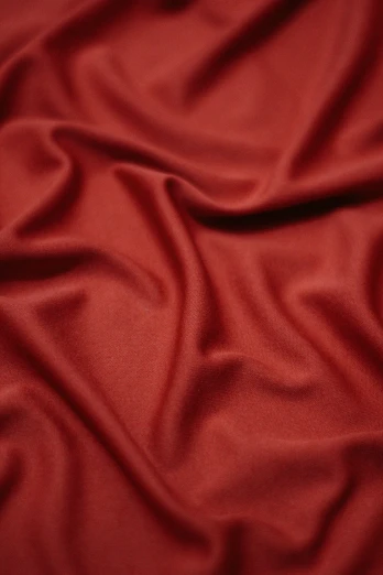 the plain, red fabric has been folded in an arc