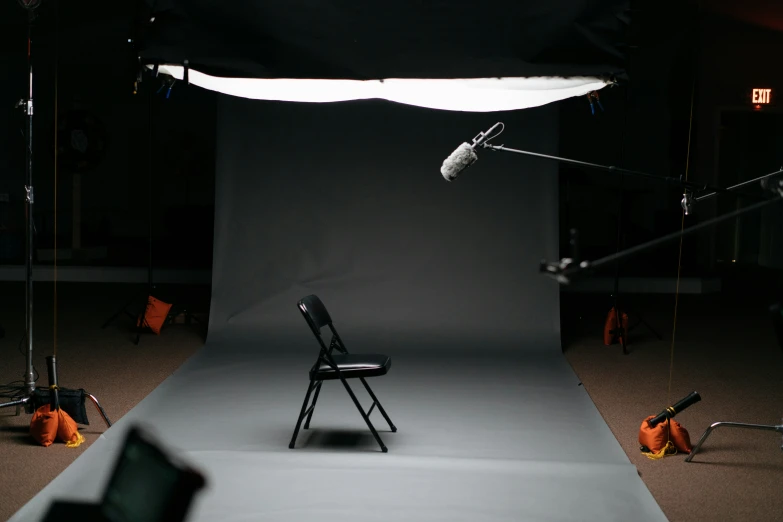 an empty chair in the dark near a pographer