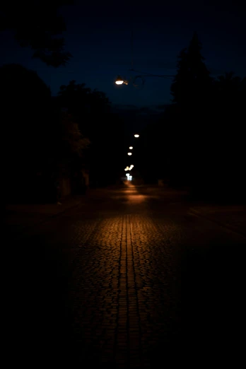 a dark, empty street with light in the distance