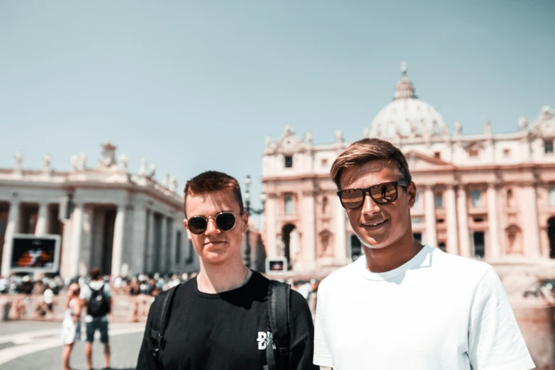 two men wearing sunglasses standing next to each other