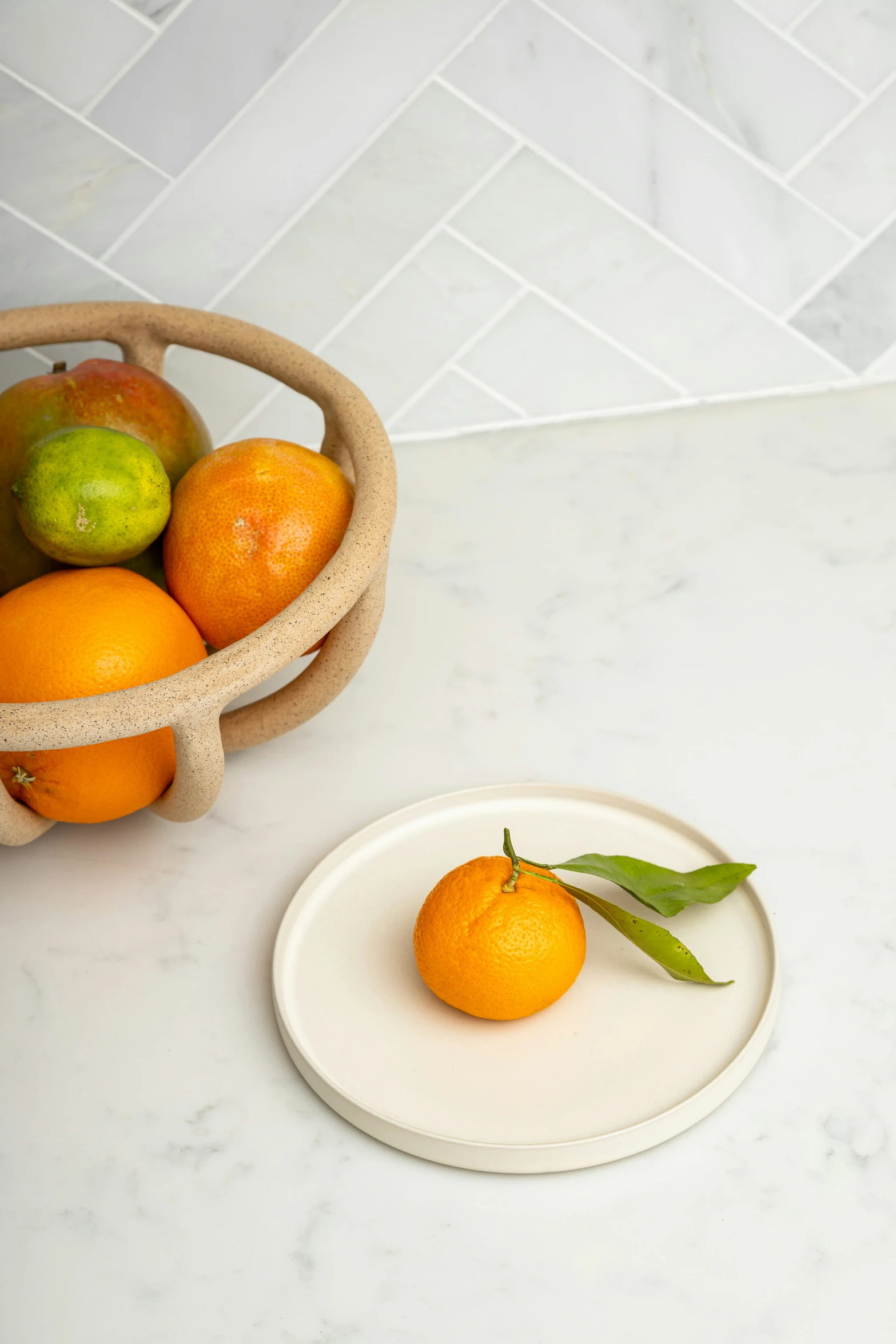 a bowl filled with oranges next to a plate