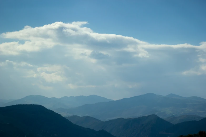 some mountains under cloudy skies in the background