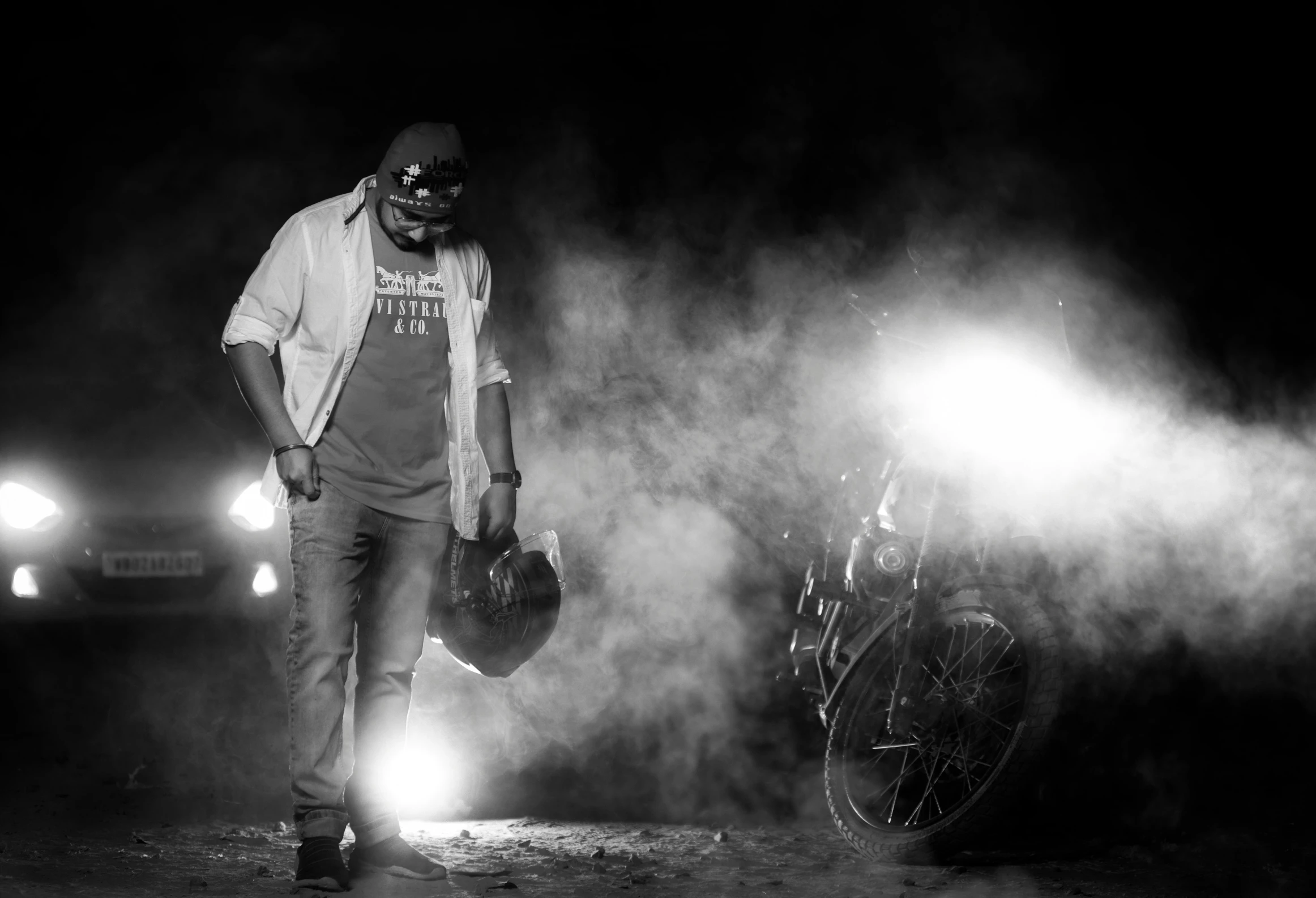 black and white po of man on motorcycle at night