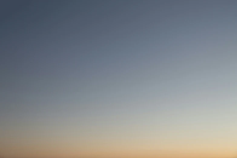 a distant kite in the sky near the beach