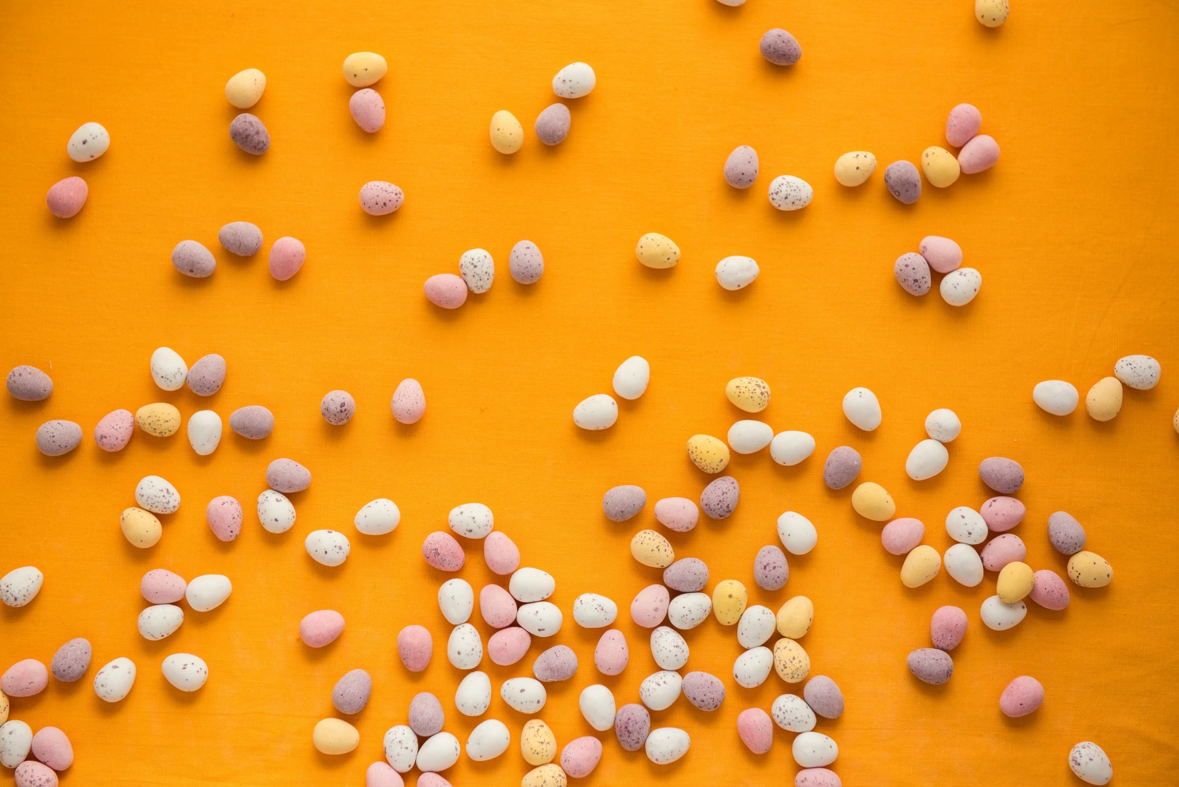 candy corn sprinkles scattered on an orange surface