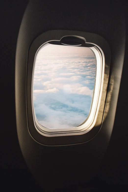 an airplane window with some very pretty clouds