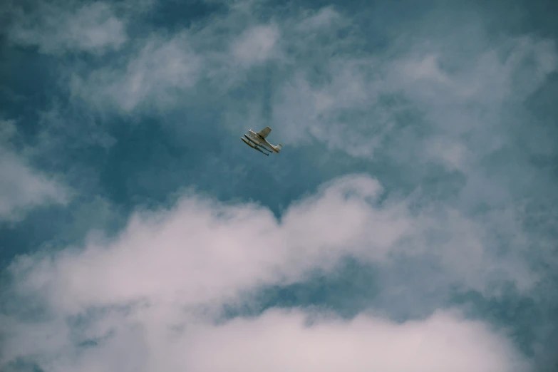 a small airplane flying through a cloudy sky