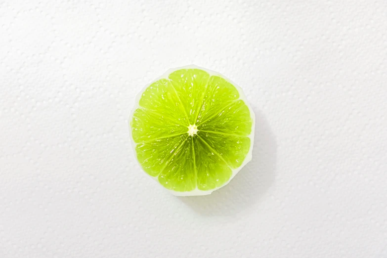 a lime is cut in half on a white surface