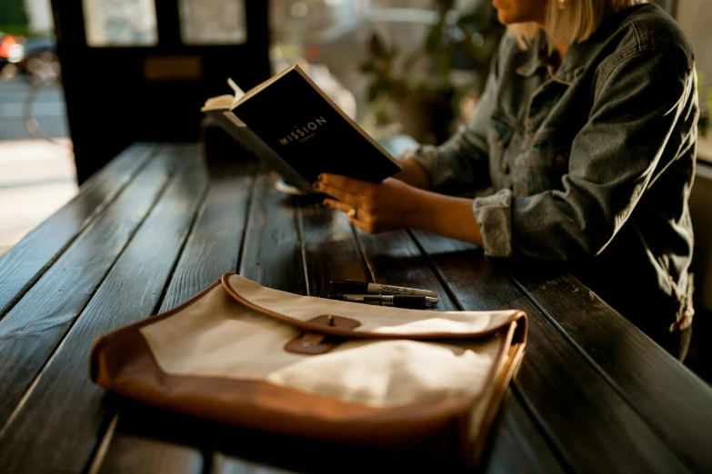 a lady is sitting at a bench with an open book