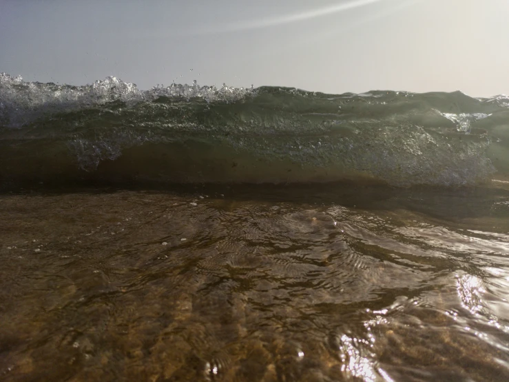 a large wave crashing in on the shore