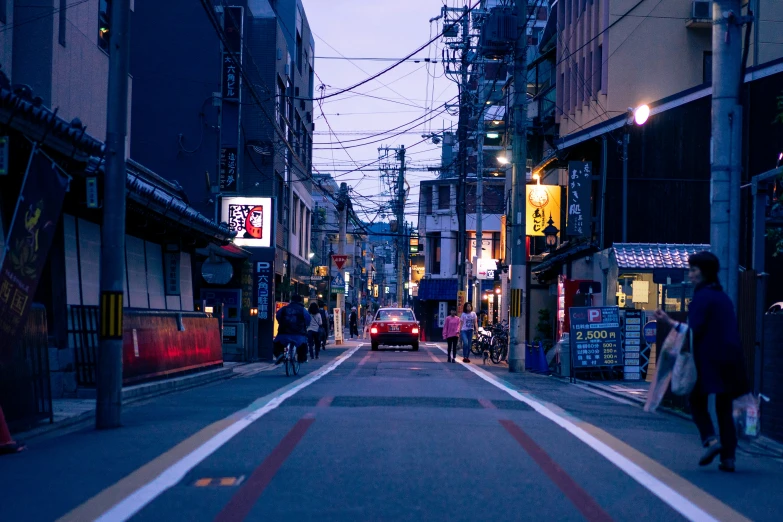 a street at twilight with some vehicles driving down it