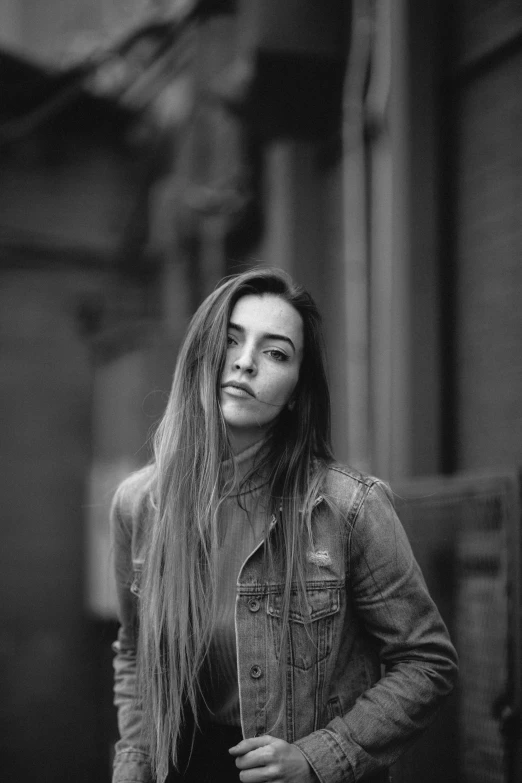 a woman with long hair wearing a jean jacket