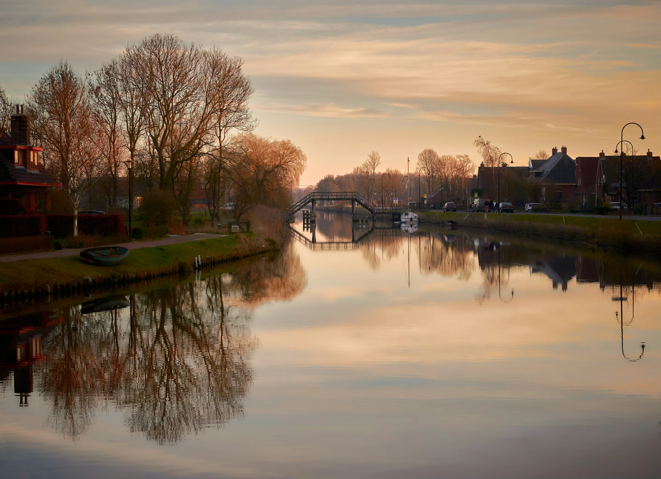 a river with houses and cars on the shore