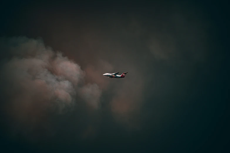 a white and blue plane flying in cloudy skies