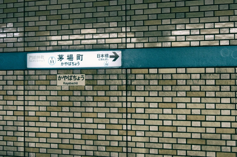 there are two street signs on the wall of a building