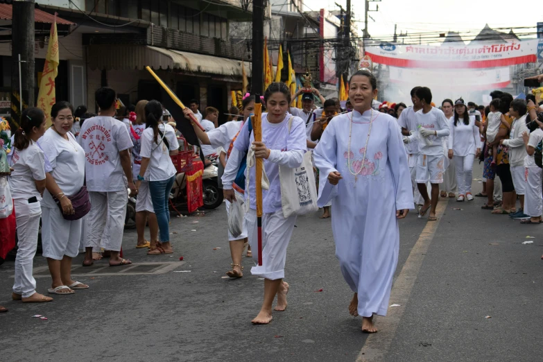 two women in blue outfits are marching down the street