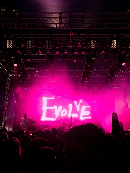 pink lighting from a stage behind a crowd