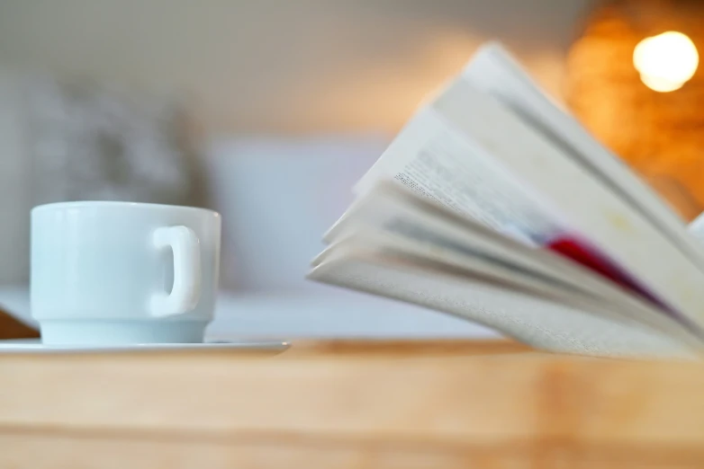 coffee mug and open books on a table