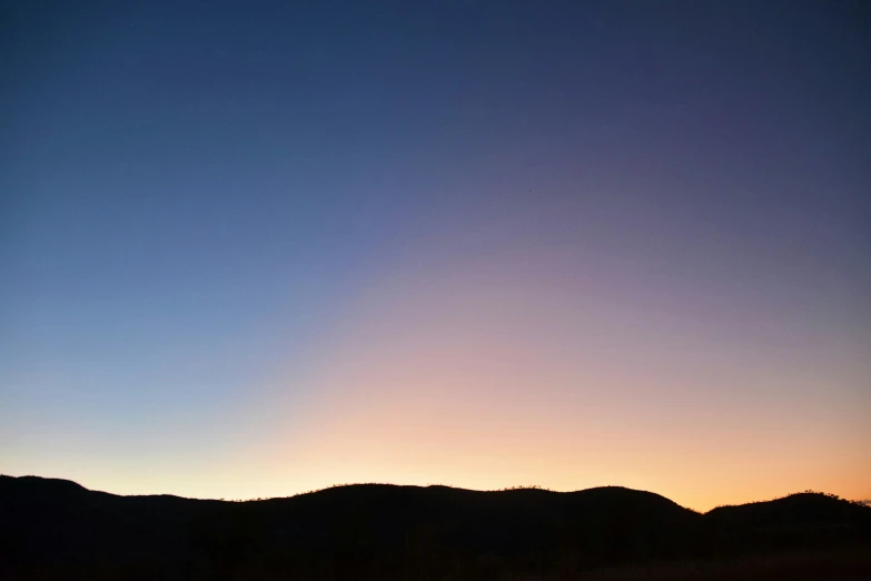 a sunset with hills in the distance