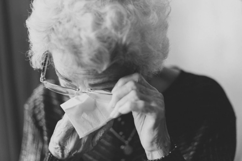 black and white po of older woman adjusting neck tie