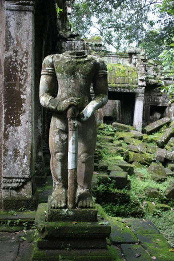 a statue stands in front of a stone doorway