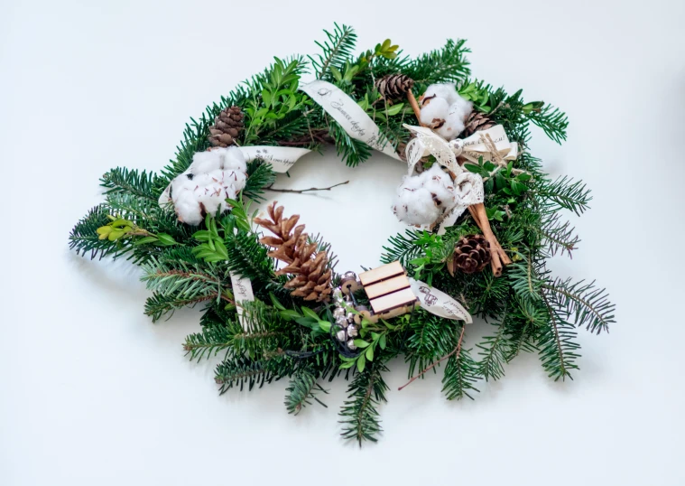 a wreath on the wall decorated with a brown teddy bear and pine cones