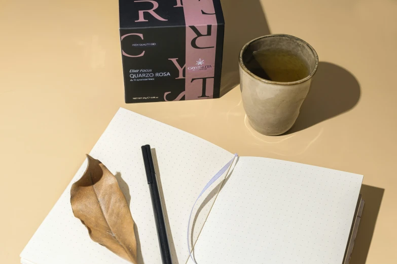 a cup of tea and an open notebook on a table