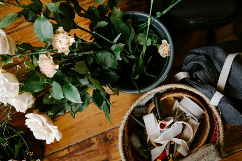 two baskets on the floor filled with flowers and a pair of scissors