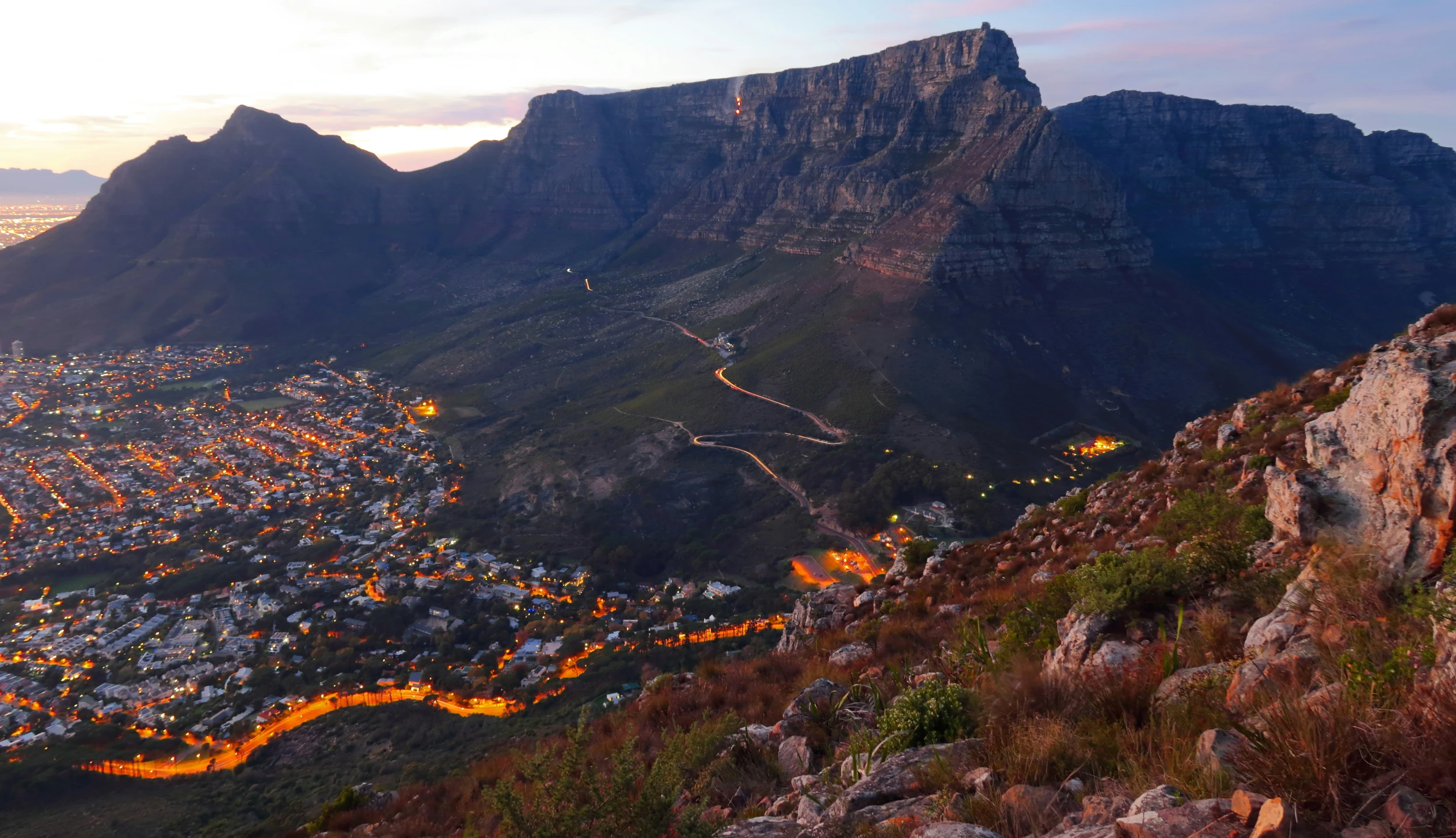 a beautiful view of a city below some mountains