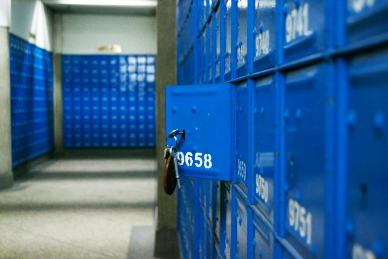 a hallway with rows of blue lockers for mail