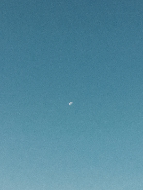 blue sky with white moon on the left
