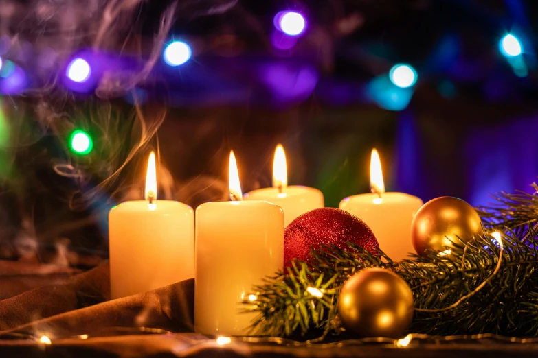 candles with christmas ornaments sitting on a table