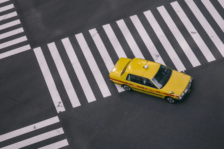 a yellow taxi is on a city street