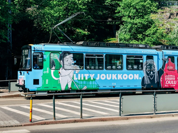 a blue trolley car with an advertit painted on the side