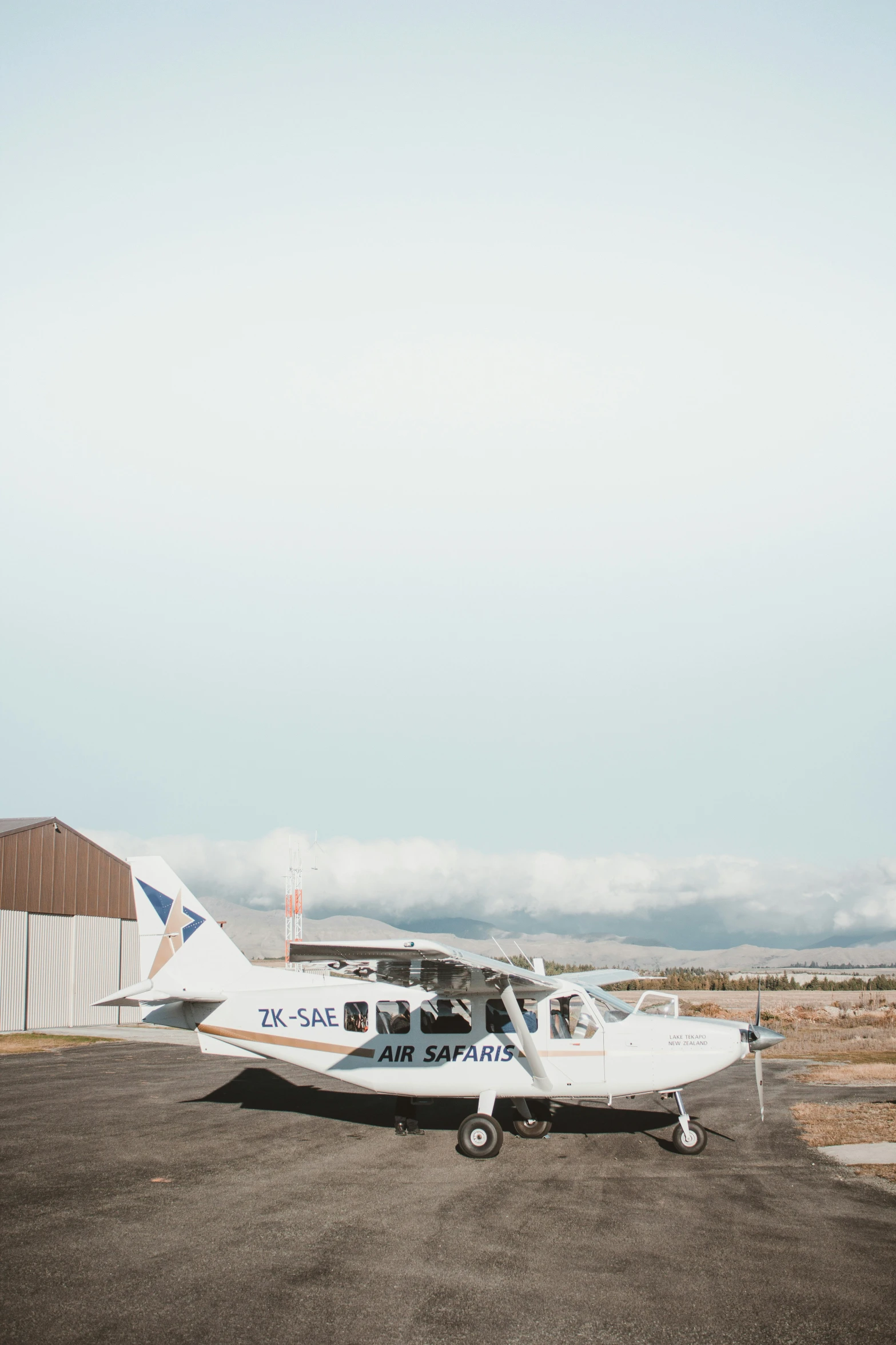 a small airplane sits on a tarmac in front of a building
