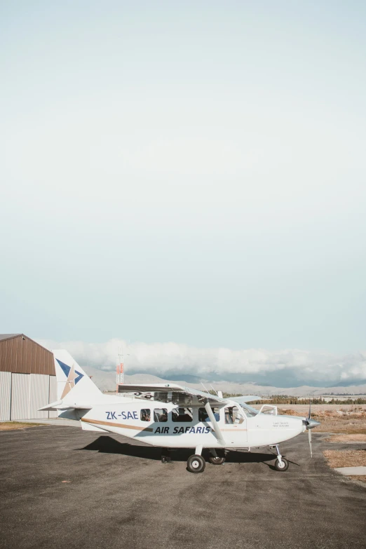 a small airplane sits on a tarmac in front of a building