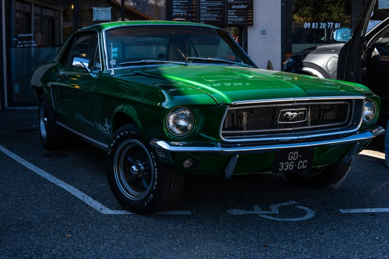 an old green mustang sits parked in a lot