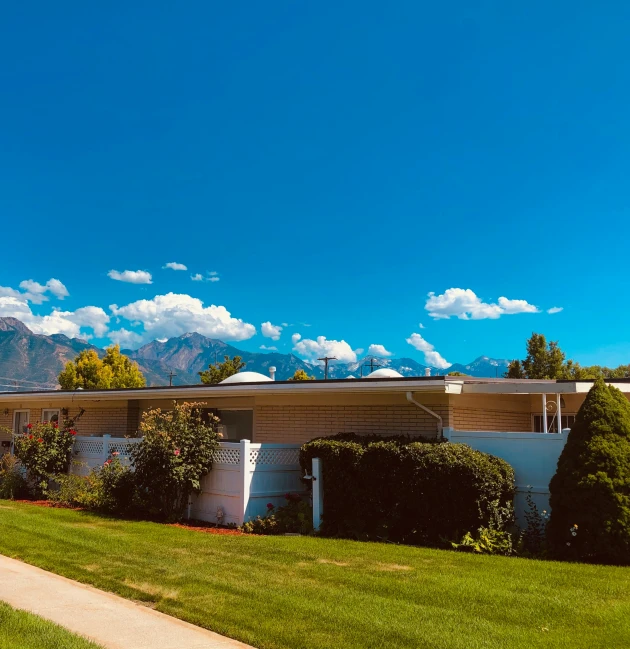 a house with mountains in the distance behind it