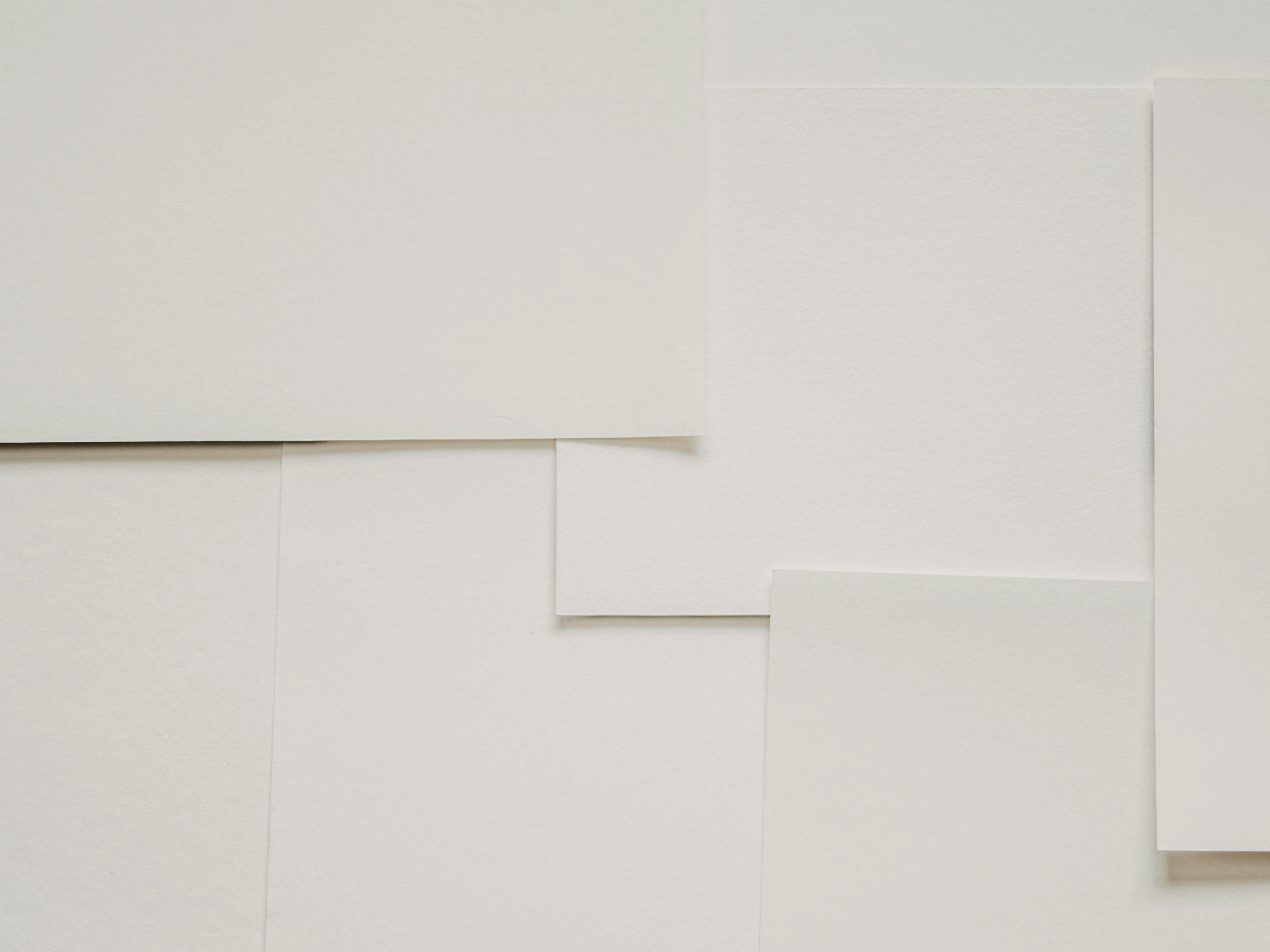 four white folded white papers on top of each other