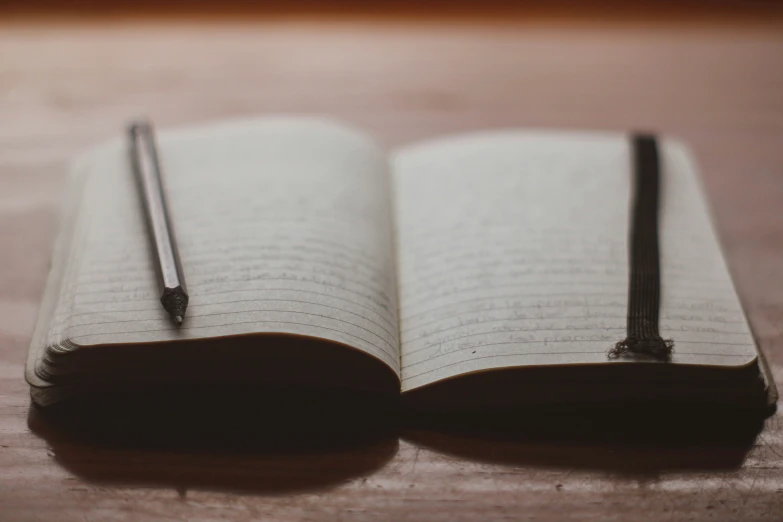 open notebook and a pencil on a table